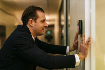 Man using face scanner to unlock door in office building. Access control facial recognition system. Biometric admittance control device for security system. Biometric admittance control device