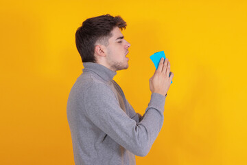 young man cold isolated on background sneezing or allergy