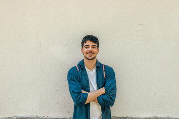 young man with backpack, portrait isolated on wall outdoors