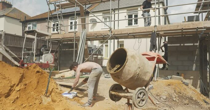 Man working on a construction site next to a cement mixer 25p in UK prores