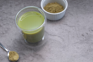 Closeup Glass Of Smoothie, Juice With Hemp Protein Powder On Table. Bowl And Spoon With Plant-derived Protein from Cannabis Plant. Superfood, Healthy Lifestyle. Horizontal Plane, Copy Space For Text.