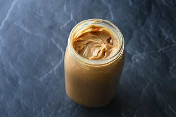 Selective focus of peanut butter jar with no label. January 24 is National Peanut Butter Day