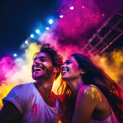 A young Caucasian couple smiles at a festival of colours , having super fun	
