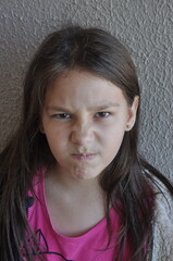 menina criança fazendo careta expressão facial de brava 