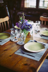 2 wine glasses with lupines on the table in a wooden cottage