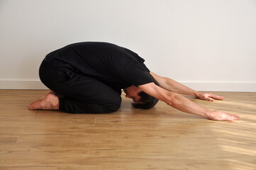 homem fazendo relaxamento, pose de yoga, alongamento e exercício corporal e mental , saúde e paz  - obrazy, fototapety, plakaty