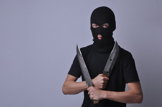 representa&ccedil;&atilde;o de criminoso bandido com rosto escondido segurando facas 
