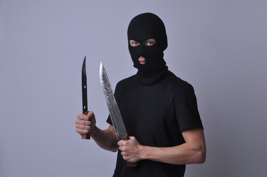 representa&ccedil;&atilde;o de criminoso bandido com rosto escondido segurando facas 