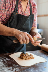 Latin Elderly Woman Making Chilean Baked Empanadas in the Authentic Ambience of her Countryside Home Kitchen. Close up