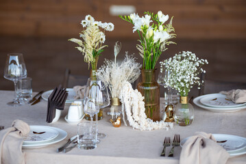 Beautiful wedding table decorations. Tablewear and bouquet of flowers.
