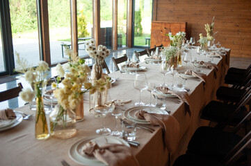 beautiful table setting with flowers and cutlery on wooden table at wedding or dinner. stylish tablewear decorations