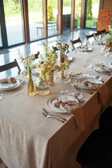 beautiful table setting with flowers and cutlery on wooden table at wedding or dinner. stylish tablewear decorations