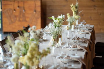 beautiful table setting with flowers and cutlery on wooden table at wedding or dinner. stylish tablewear decorations
