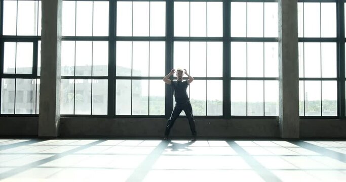 Talented Caucasian dancer, dressed in latex pants and high heels. Against the backdrop of a window, his expressive movements and alluring charisma create an intoxicating dance experience.