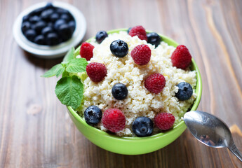Cottage cheese with fresh berries in a bowl on a table.