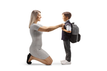 Full length profile shot of a mother helping son getting ready for school
