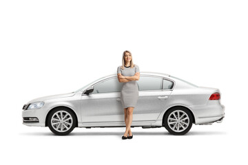 Full length portrait of a young woman leaning on a silver car