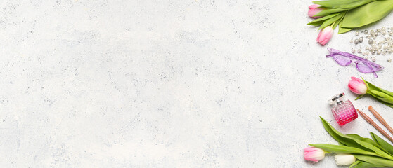 Stylish female accessories, bottle of perfume and tulip flowers on light background with space for text