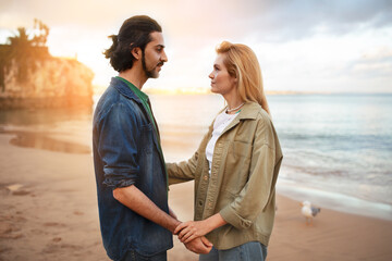 Romantic Young Man And Woman Standing On The Beach At Sunset Time