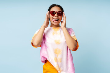 Smiling African American woman wearing trendy tie dye t shirt and sunglasses