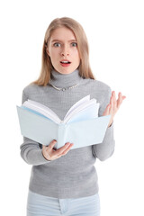 Shocked young woman reading book on white background