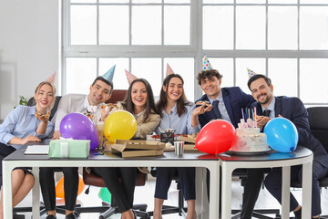 Group of business people eating pizza at birthday party in office