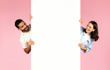 Happy millennial man and woman looking at blank white board