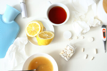 Medications with lemon, tea and soup on table in room, closeup