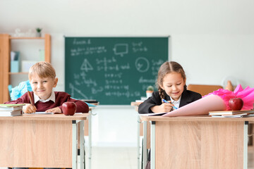 Classmates with school cones sitting at desks in classroom
