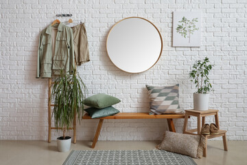 Interior of hallway with wooden bench, mirror and houseplants