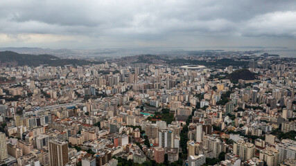 Obraz premium Aerial view of Rio de Janeiro on a cloudy day, in the neighborhoods of Tijuca and adjacencies and green areas such as the Tijuca National Park. In the background, Maracanã stadium and Guanabara Bay.