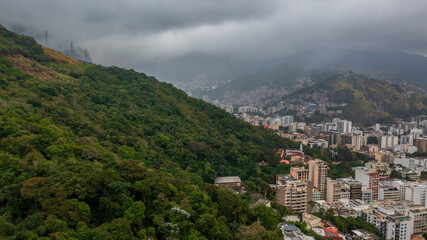 Aerial view of Rio de Janeiro on a cloudy day, in the neighborhoods of Tijuca and adjacencies and green areas such as the Tijuca National Park. In the background, Maracanã stadium and Guanabara Bay.