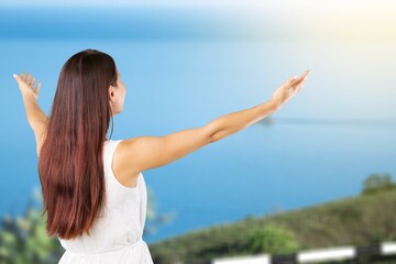 Happy young tourist woman raising arms