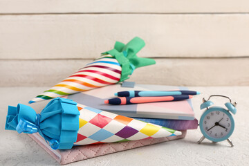 Colorful school cones and stationery on grunge white table near wooden wall