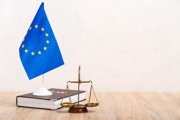 Fototapeta na wymiar European Union flag, scale of justice and law book on wooden table