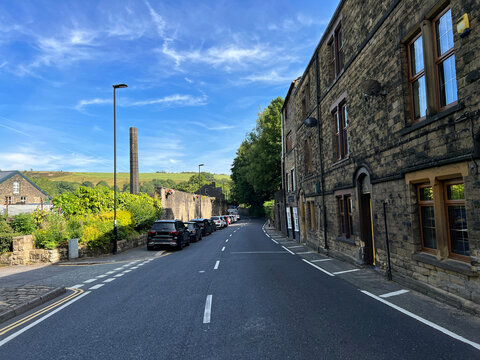 Fototapeta View along, Millgate, with Victorian buildings, and old trees and hills, in the far distance, Delph, Oldham, UK