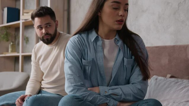 Upset offended woman wife offense to husband family quarrel in bedroom marriage problem relationship difficulties couple sit separately on bed guilty man boyfriend try to apologize after fight breakup