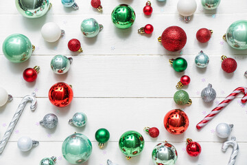 Frame made of different Christmas balls on white wooden background