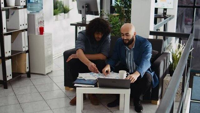 Research team verifying reports for business development plan, reading archived documents with analytics in office. Coworkers reviewing notes in open space, management expertise.