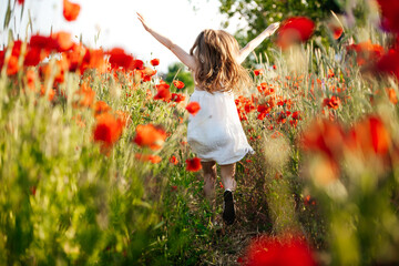 girl running in a poppy field, developing hair