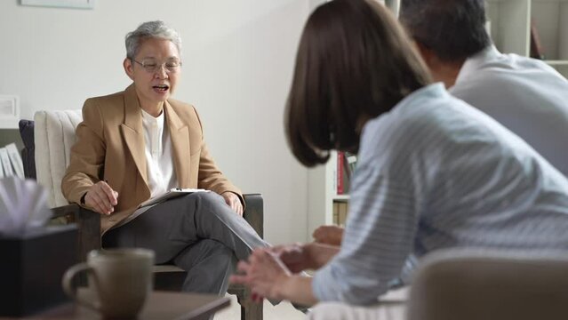Mature Asian couple consulting couple relationship counselling to solve problems