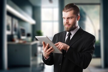 Handsome young businessman works on digital tablet