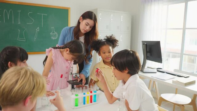 Adorable student learn with teacher in classroom at elementary school. 