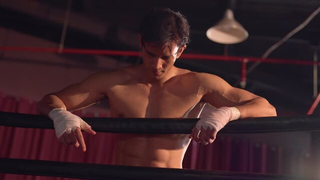 Asian professional sportsman doing boxing exercise in the boxing ring. 