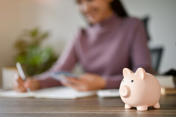 Close-up image of a piggy bank on a businesswoman's desk. savings, financial, investment