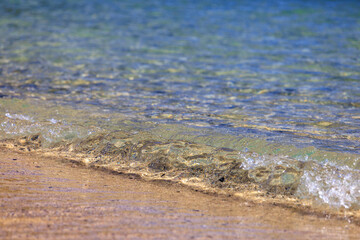 砂浜に打ち寄せる透明感のある小さな波