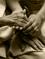 Young girl's hand holding old woman's wrinkled hands