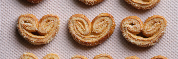 Group of heart shaped cookies on white textile.