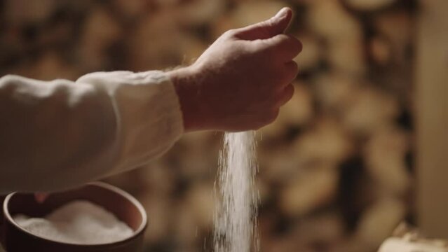 Slavic Man Pouring Salt In Wooden Bowl, Cooking Tradition In Old Russian Or Ukrainian Village