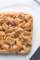 Top view of homemade onion focaccia on a white background, Flatlay of focaccia with red onion topping, fresh homemade focaccia bread